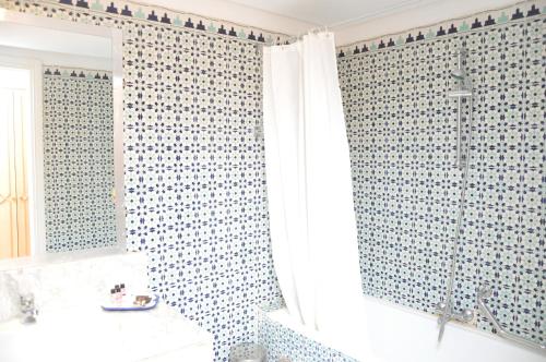 a bathroom with a blue and white tiled shower curtain at Dar El Manara Djerba Hotel & Aparts in Houmt Souk