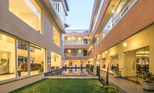 an indoor courtyard of a building with a lawn in the middle at Regenta Central North Goa, Arpora in Arpora
