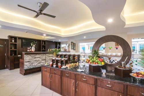 a large kitchen with a counter with food on it at Regenta Central North Goa, Arpora in Arpora