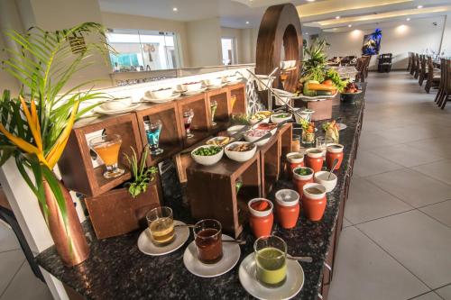 a buffet line in a restaurant with plates of food at Regenta Central North Goa, Arpora in Arpora
