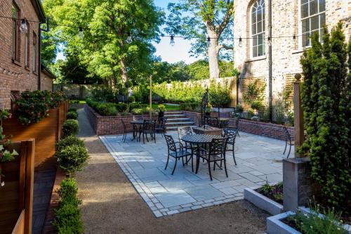 a patio with tables and chairs in a yard at Stauntons on the Green Hotel in Dublin