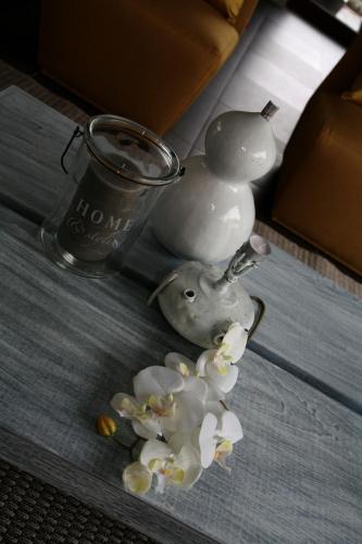 a group of white flowers in a vase and a cup at Casa Valxisto in Penafiel