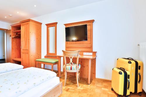 a bedroom with a bed and a desk with a television at Hotel-Restaurant zum Ochsen in Schallstadt