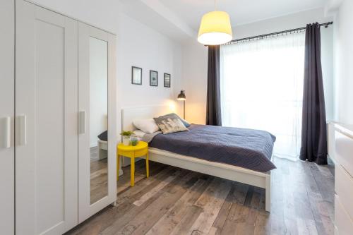 a bedroom with a bed and a yellow table and a mirror at Arianska Residence in Kraków