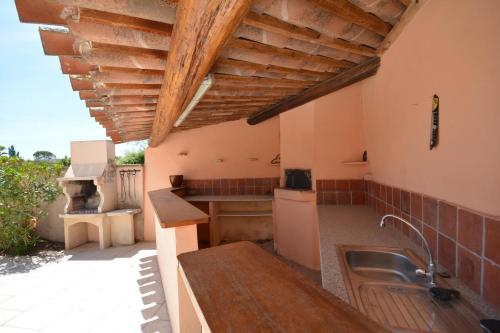 cocina con fregadero y techo de madera en Mas et Gite de la Picholine en LʼIsle-sur-la-Sorgue