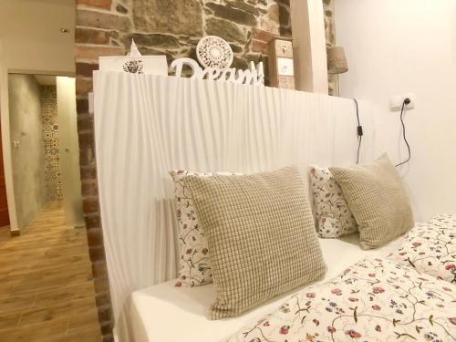 a white canopy bed with pillows on top of it at Ameisenberg Appartement in Kurort Oybin
