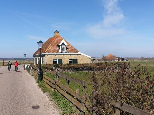 a person riding a bike in front of a building at Unique holiday home on Texel on the edge of Den Hoorn in Den Hoorn