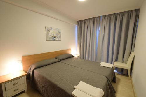 ベニドルムにあるCarolina III - Fincas Arenaのベッドルーム1室(ベッド1台、窓、椅子付)