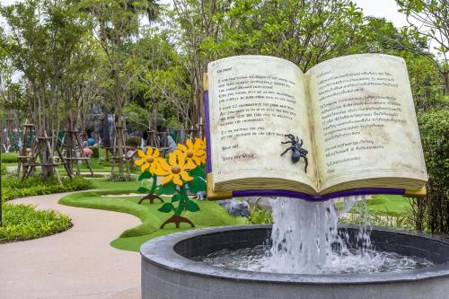 an open book sitting on top of a fountain in a park at SO/ Sofitel Hua Hin in Cha Am