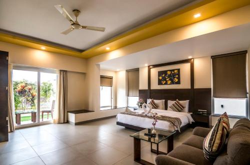 Habitación de hotel con cama y sofá en Regenta Central North Goa, Arpora, en Arpora