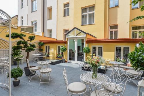 a patio with tables and chairs in front of a building at Hotel Hastal Prague Old Town in Prague