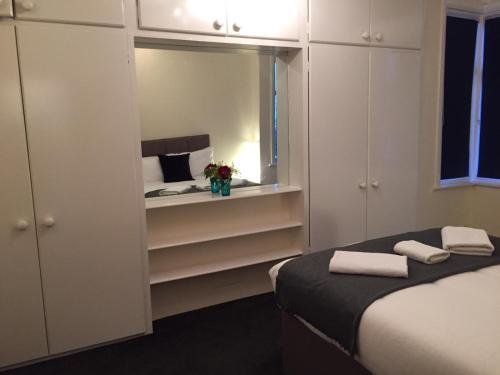 ein kleines Schlafzimmer mit einem Bett und einem Spiegel in der Unterkunft Marble Apartments Tooting House in London