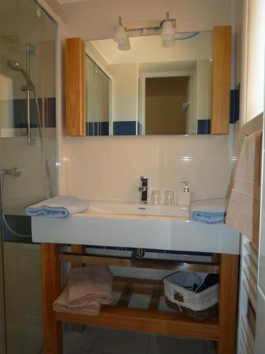 une salle de bain avec un lavabo et un miroir dans l'établissement L' Escale Tranquille, à Sète