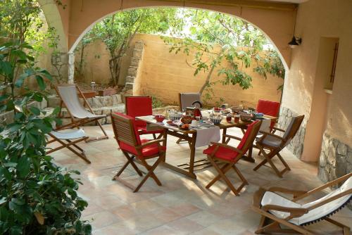 un patio con tavolo, sedie e arco di L' Escale Tranquille a Sète