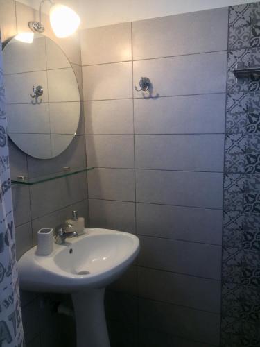 a white bathroom with a sink and a mirror at Galazia Nera Apartments in Áyios Andréas Messinias