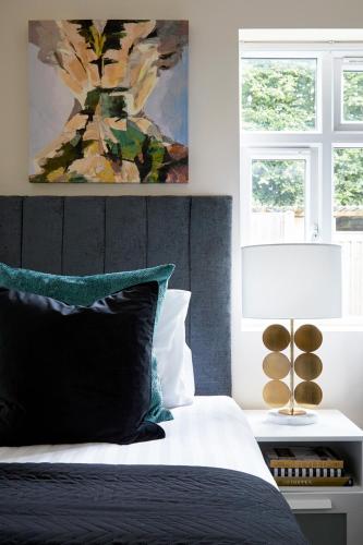 a bedroom with a bed with a painting on the wall at Aisiki Living at Alexandra Road, 2-Bedroom & 2-Bathroom with King or Twin Beds with Free Wi-Fi and Parking Space in Watford