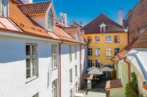 an alley in a city with buildings and tables at Meriton Old Town Garden Hotel in Tallinn