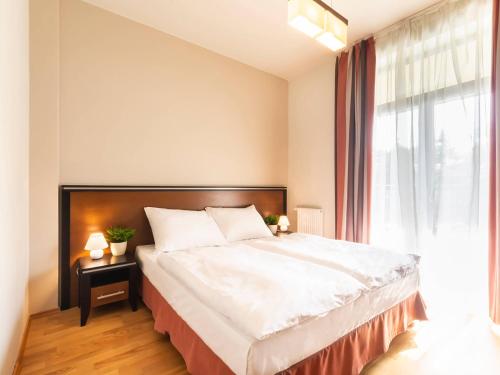 a bedroom with a large bed and a window at VacationClub – Diune Apartament 38 in Kołobrzeg