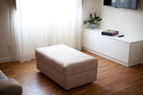 a white living room with a ottoman in a room at I VICOLI Exclusive Apartments in Fondi