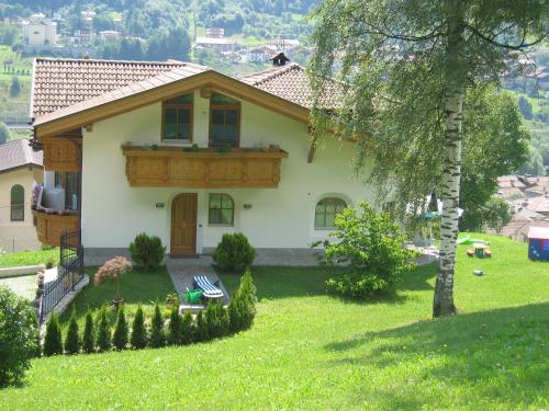 B&B Rendena Chalet في Strembo: منزل به شجرة في الفناء