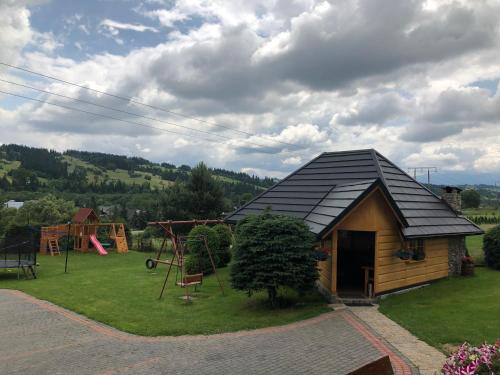 a small house with a playground and a play area at Pokoje Gościnne Kornelia- Jacuzzi, sauna ! in Biały Dunajec