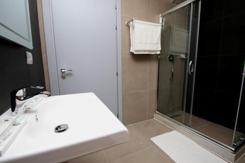 a bathroom with a white sink and a shower at Hotel Keshtjella Llogara in Vlorë