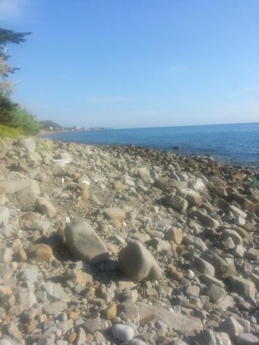 a group of rocks on a beach near the water at B&B Mazzarella in San Mauro Cilento