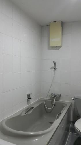 een badkamer met een bad en een toilet bij West Wing Mansion in Bangkok