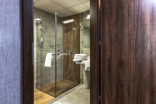 a bathroom with a glass shower with a toilet at Vulcan Hotel in Szczecin