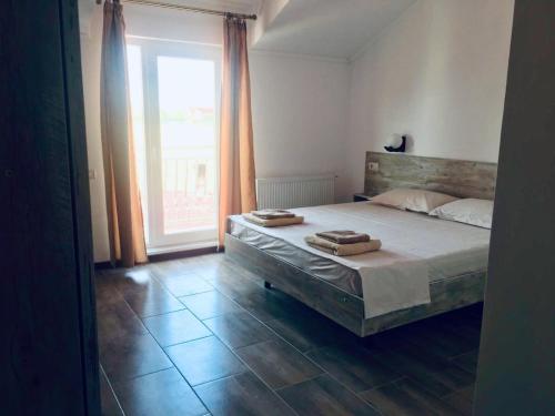 a bedroom with a bed with two towels on it at Vila Alexia in Corbu
