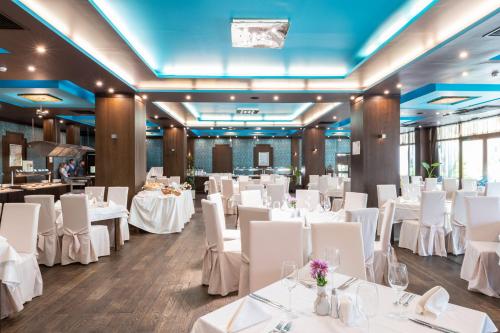 a banquet hall with white tables and white chairs at Garden of Eden Complex in Sveti Vlas