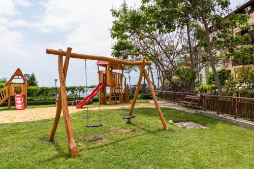 a playground in a park with a swing at Garden of Eden Complex in Sveti Vlas