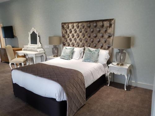 a bedroom with a large bed and a mirror at Great Hallingbury Manor in Bishops Stortford