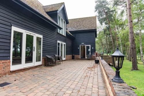 a house with a brick patio in front of it at Great Hallingbury Manor & Lodges London Stansted in Bishops Stortford