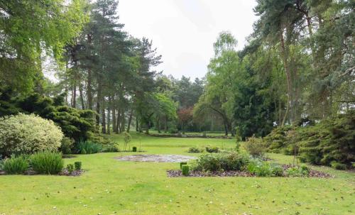 a park with green grass and trees and a garden at Great Hallingbury Manor & Lodges London Stansted in Bishops Stortford