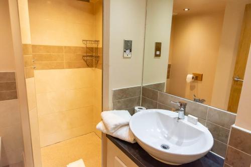 a bathroom with a sink and a shower at Great Hallingbury Manor & Lodges London Stansted in Bishops Stortford