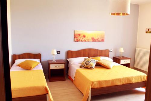 ジャルディーニ・ナクソスにあるVilla i Minnulareddiのベッドルーム1室(黄色いシーツを使用したベッド2台付)