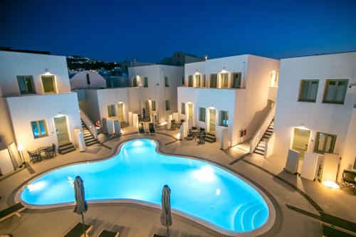 a large pool in front of a building at night at Kallos Imar Boutique Hotel in Mesaria