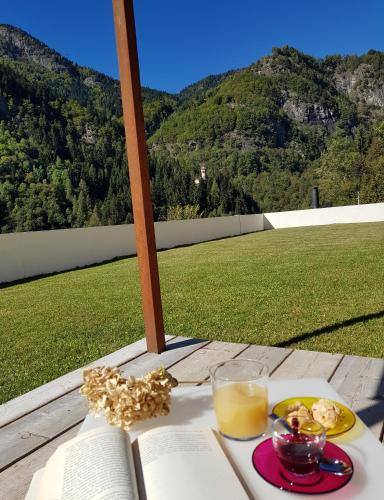a table with a book and a glass of orange juice at Villa Ottocento in Campertogno