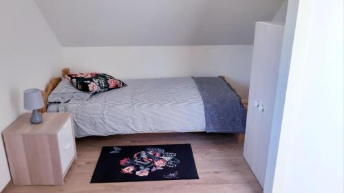 a small bedroom with a bed and a rug on the floor at Orawski Letniskowiec in Zubrzyca Dolna
