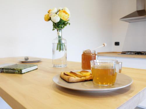 een bord brood en een glas sap op een tafel bij La Dimora apartments in Siculiana