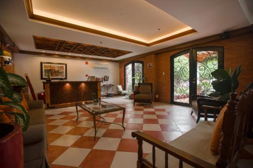 a living room with a checkered floor and windows at Hotel Emilia in Davao City