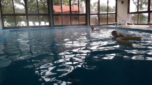 una persona nadando en una piscina en Residencial Pousada Serrano, en Gramado