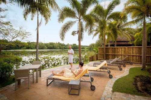 a man standing on a patio with a woman in a chair at ROBINSON KHAO LAK in Khao Lak