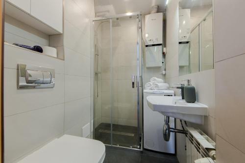 uma casa de banho com um chuveiro, um WC e um lavatório. em ShortStayPoland Staszica (B76) em Varsóvia
