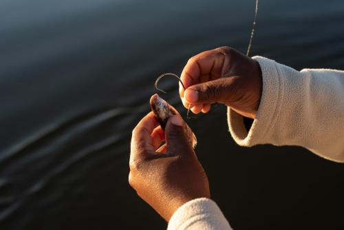 two hands holding onto a piece of string at Ichingo Chobe River Lodge by Mantis in Punga