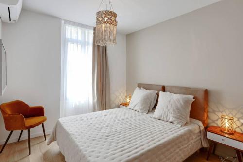 une chambre blanche avec un lit et une chaise dans l'établissement Luxe et Confort - Proche Palais et plages - A/C, à Cannes