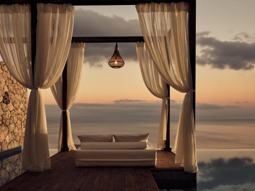 a living room with a couch in front of a window at Emerald Villas & Suites - The Finest Hotels Of The World in Agios Nikolaos