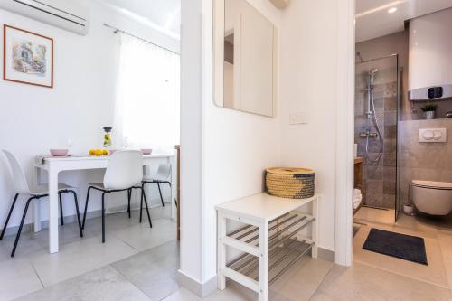 a kitchen and dining room with a white table and chairs at Apartments Marija in Baška