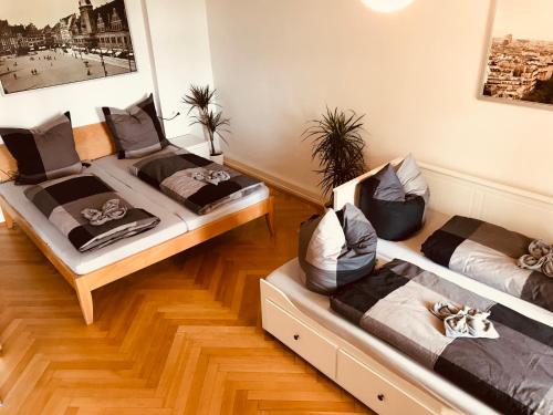 Habitación con suelo de madera y 2 camas. en Ferienwohnungen und Apartmenthaus Halle Saale - Villa Mathilda, en Halle an der Saale